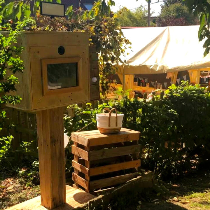 Piko Event | Photo de photobooth loué pour anniversaire, disposé dans le jardin, entouré de feuilles